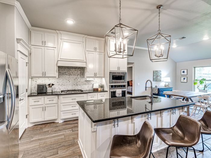 White kitchen with a granite island at 1614 Skyler Way