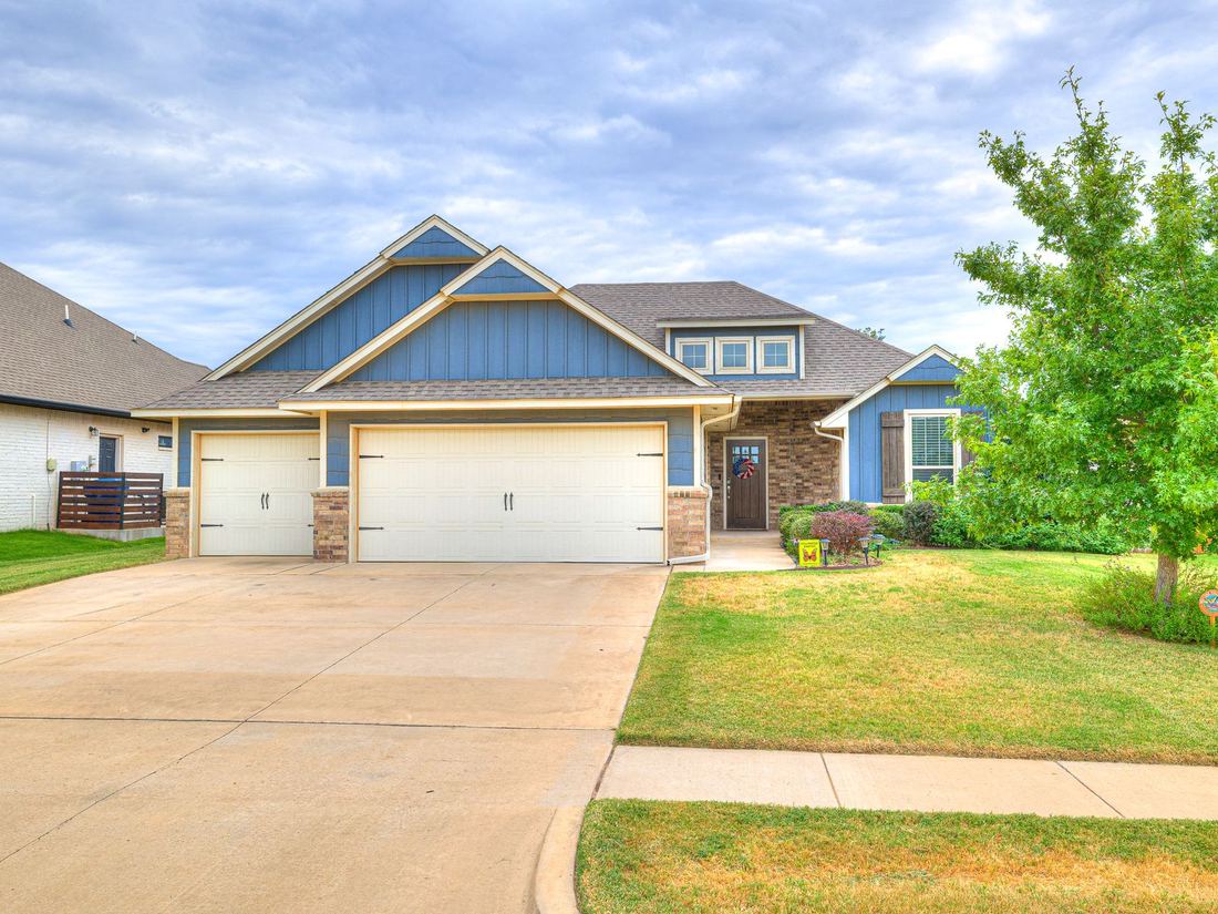 Front of 1614 Skyler Way, a blue and brick home in Norman