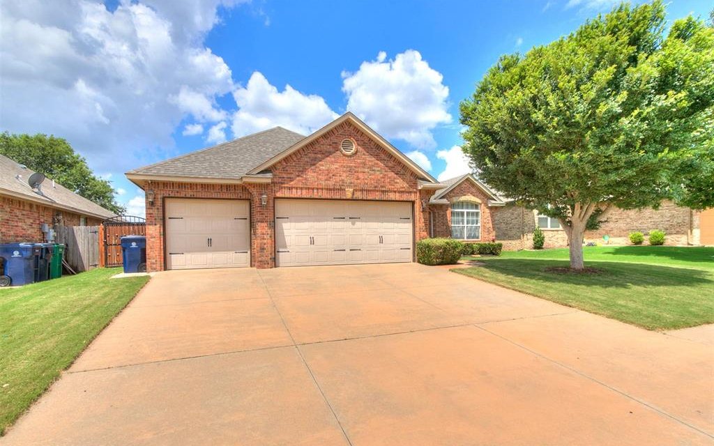 Brick front and three-car garage of 7609 Harold Drive in Yukon